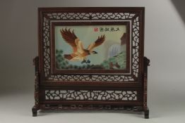 A PIERCED CHINESE SCREEN painted with an Eagle on a glass panel. 38cms high.
