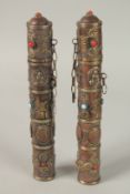 A PAIR OF TIBETAN METAL SCROLL HOLDERS with calligraphy and stones. 23cms long.