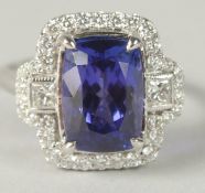 A STYLISH 18CT WHITE GOLD RING SET WITH A RECTANGULAR CUSHION AAA TANZANITE AND RBC AND PRINCESS CUT