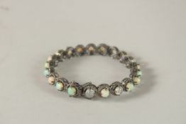A GOOD OPAL AND DIAMOND BANGLE set with twenty four opals.