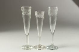 A PAIR OF FLUTE GLASSES engraved with fruiting vines. 22cm high and another with leaves, 20cm