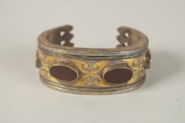 A SILVER GILDED BRACELET SET WITH FOUR RED STONES.
