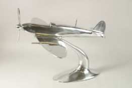 A LARGE CHROME SPITFIRE on an oval base. 50cms long x 35cms high.