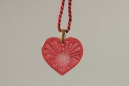 A LALIQUE RED GLASS SHAPED PENDANT, boxed.