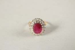 AN 18CT GOLD RUBY AND DIAMOND CLUSTER RING. Ring size (O).