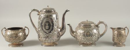 A GOOD VICTORIAN SILVER FOUR PIECE TEA SET with ribbon and laurel leaves comprising: tea pot, hot