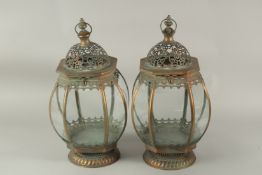 A PAIR OF METAL GLAZED CIRCULAR LANTERNS. 55cms high.