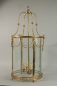 A GOOD BRASS AND GLASS CIRCULAR HANGING LANTERN with ribbon motif. 80cm high 32cm diameter.