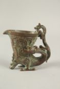 A SMALL BRONZE LIBATION CUP entwined with a dragon. 7cms.