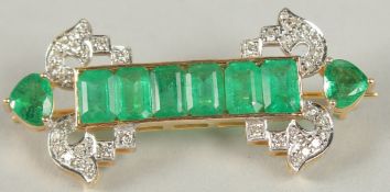 AN ART DECO STYLE BAR PIN BROOCH IN YELLOW METAL SET WITH EMERALDS AND DIAMONDS, boxed. Mixed cut