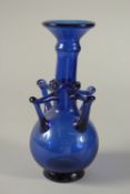 AN 18TH-19TH CENTURY MUGHAL INDIAN BLUE GLASS VASE, with four handles, 25cm high.