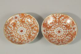 A PAIR OF CHINESE COPPER RED AND WHITE PORCELAIN DRAGON DISHES, each painted with four dragons and
