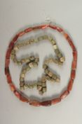 A POSSIBLY ANCIENT STRING OF AGATE BEADS, and another of blue/green faience beads, (2).