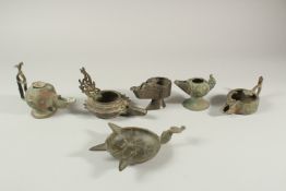 A COLLECTION OF SIX EARLY ISLAMIC PERSIAN 10TH-12TH CENTURY BRONZE OIL LAMPS, of various forms, (