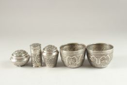 A REPOUSSE SILVER LIDDED CANISTER, together with two other silver boxes and a pair of engraved