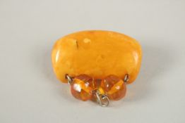 AN AMBER BROOCH, amber piece 4cm x 2cm.