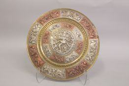 A 19TH CENTURY INDIAN TANJORE SILVER AND COPPER INLAID DISH, with an embossed deity, birds, and