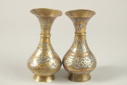 A NEAR PAIR OF ISLAMIC CAIROWARE SILVER AND COPPER INLAID VASES, with panels of calligraphy, 14.