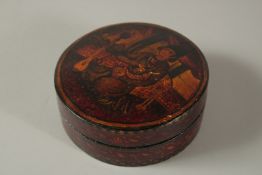 A FINE 19TH CENTURY PERSIAN QAJAR LACQUERED PAPIER MACHE CIRCULAR BOX, painted with a seated figure,