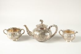 A FINE CHINESE SILVER TEA SET, maker mark 'HM', comprising a teapot, milk jug, and sugar bowl,