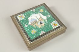 A PERSIAN ENAMELLED WHITE METAL BOX, depicting a mosque, 14cm square.