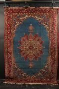 A PERSIAN BLUE GROUND AND RED DESIGN RUG, 180cm x 122cm.