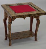 A MOROCCAN MARQUETRY INLAID FOLDING GAMES TABLE, with open-out inset top and folding out leg.
