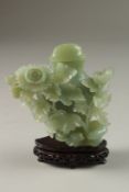 A CHINESE FINELY CARVED JADE LIDDED VASE, on a fitted wood stand, the body with foliate relief