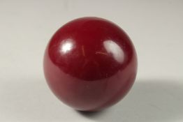 A LARGE CHERRY AMBER BAKELITE OR CATALIN BALL, 7cm, weight: 290g.