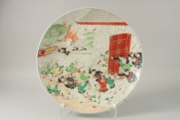 A JAPANESE ENAMEL PAINTED PORCELAIN CHARGER, depicting a battle scene with gilded highlights, 46cm