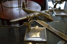 An aluminium model of an aeroplane on stand.