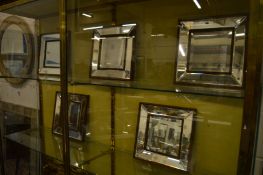 A set of five small decorative mirrors.