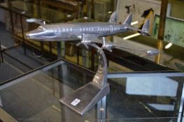 An aluminium model of an aeroplane on stand.