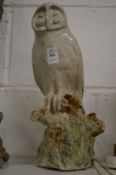 A Continental pottery model of an owl seated on a tree stump.
