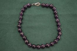 An amethyst bead necklace.
