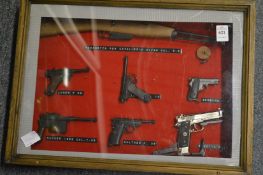 An unusual framed and glazed collection of miniature pistols and a rifle.