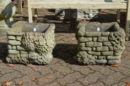 A pair of reconstituted stone planters.
