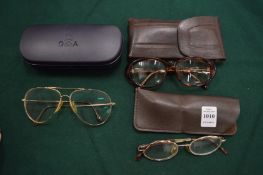 Three cased pairs of glasses.