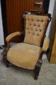 A Victorian button upholstered walnut framed open armchair.