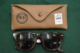 A cased pair of Ray-Ban sunglasses.