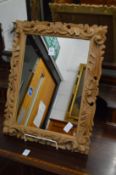 A small mirror with carved pine frame.