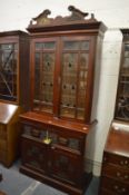 A late Victorian walnut secretaire cupboard bookcase with carved decoration and leaded light doors.