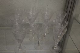 A small group of engraved and cut glass wine glasses.