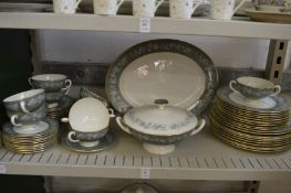 A quantity of Wedgwood dinnerware, green with a green border, decorated with flowers.