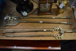 A brass three piece fireside set.