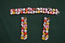 A silver bracelet and earring set, both set with colourful stones.