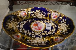 A Royal Crown Derby oval shaped dish, blue ground with gilt decoration and floral panels.