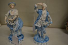 A pair of blue and white decorated French porcelain figures of a young lady selling flowers with her