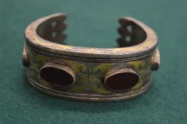 A silver gilt bracelet set with four red stones.