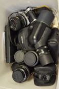 A Nikon camera with numerous lenses and other items.